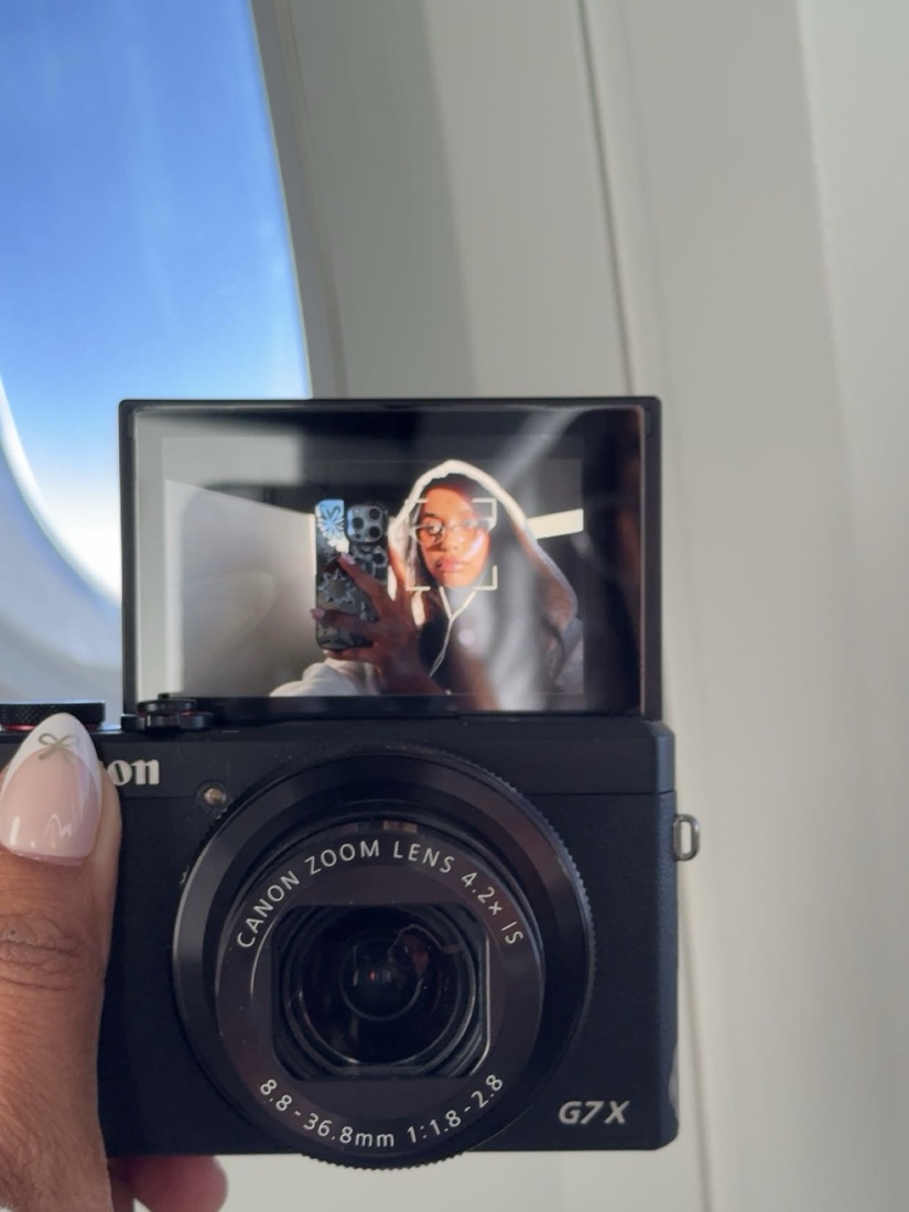 Camera screen showing Melanie travelling on a plane
