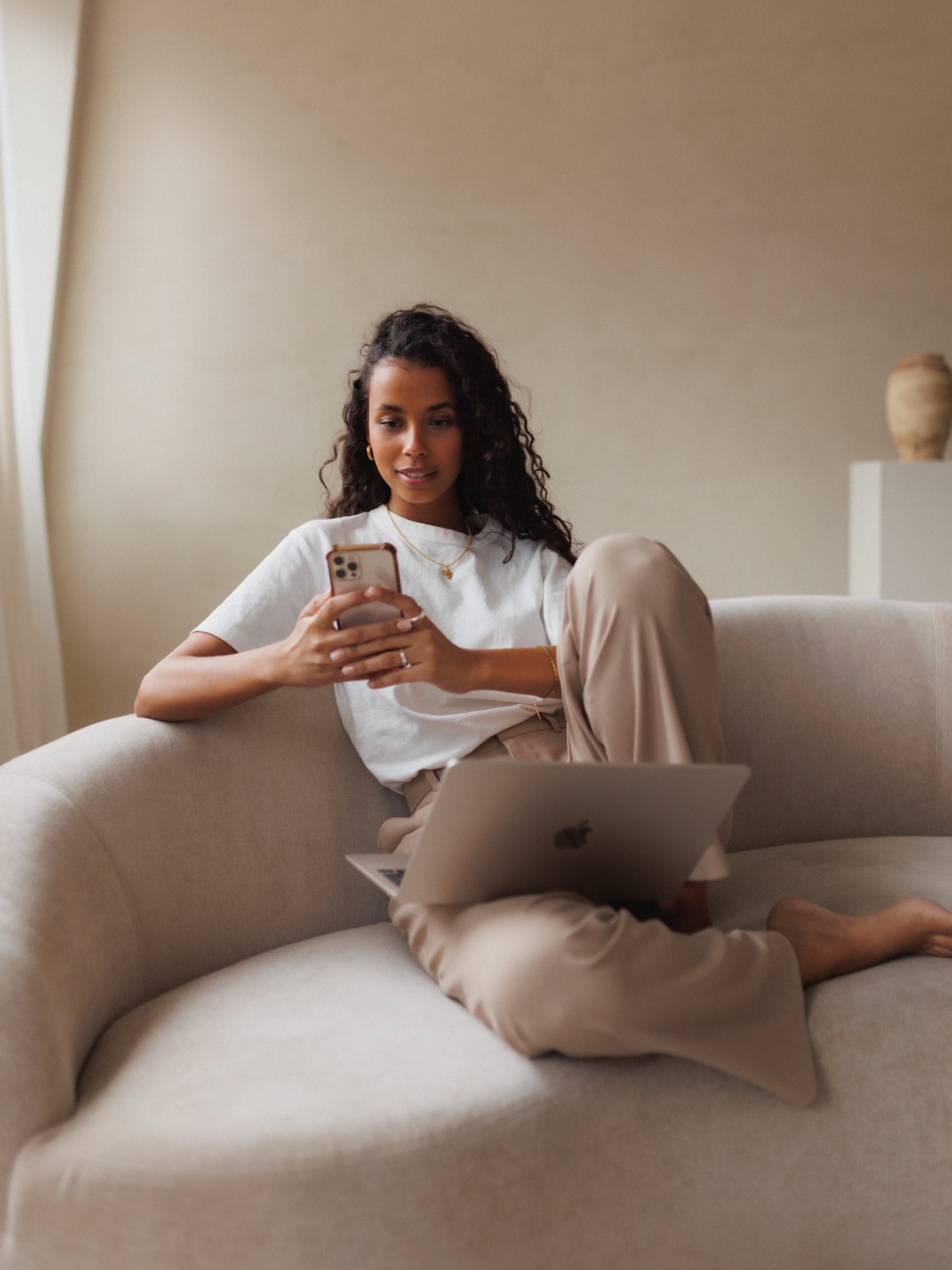 Melanie relaxing on a sofa with her phone